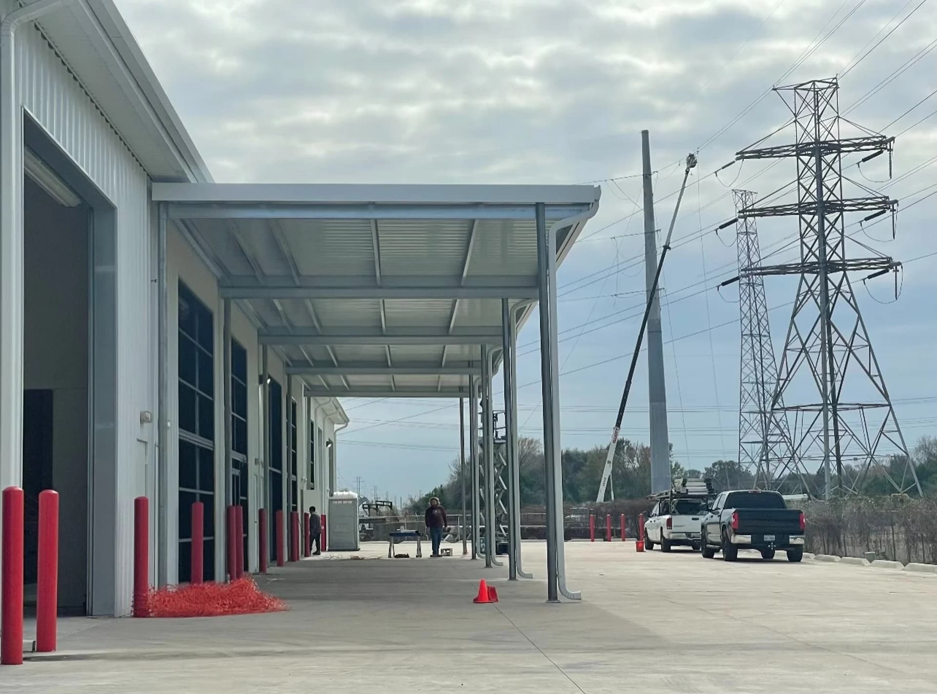 Long commercial metal canopy along a white metal building